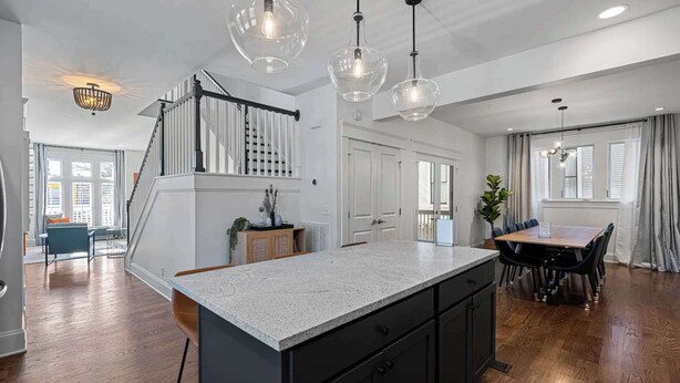 A spacious kitchen with a granite countertop, black cabinets, and pendant lighting. - Walk to Five Points | 2 Patios + Private Garage       |     Close to Dining and Bars, Board Games, 10 Mins to Broadway, 24 Hour Hospitality (Nashville)