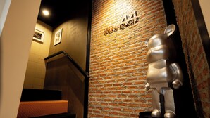 A staircase with a brick wall and a metal sculpture.