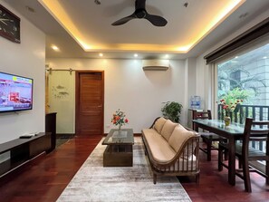 Departamento de lujo, vista a la ciudad | Área de sala de estar | Televisión 