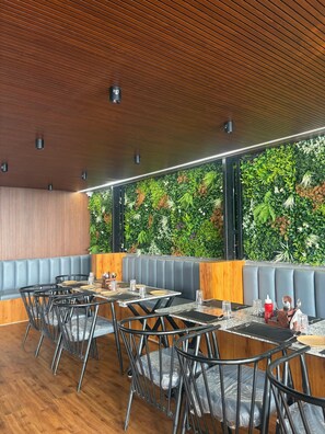 Un restaurant avec un plafond en bois, un mur vert et un espace réservé aux clients.