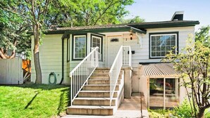 A two-story house with a front porch, a small covered porch, and a visible garage door.