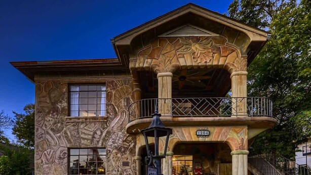 A two-story building with a stone facade, a balcony with a wrought iron railing, and a sign with the number 1204. - Historic Artist Home-Walk to SXSW+6th St+UT (Austin)