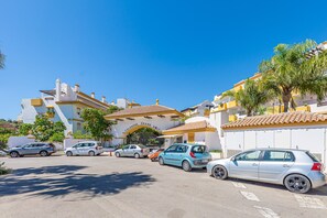 A parking lot with several cars, a building with a sign reading "Calanova Grand Golf", and a clear blue sky. - Calanova Grand Golf stunning apartment (Mijas Costa)