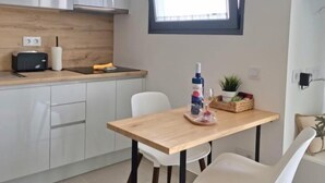 Una cocina moderna con armarios blancos, encimera de madera, un tostador y una ventana sobre el fregadero.