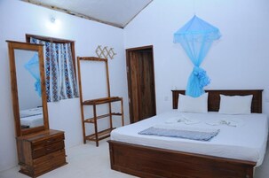 Un dormitorio con una cama de madera, un aparador de madera, un espejo y un dosel azul.