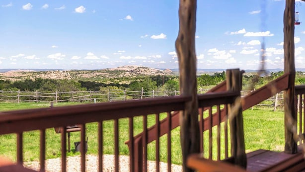 A wooden deck with a view of a mountainous landscape.