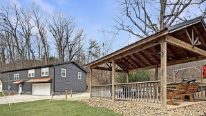 Un bâtiment à deux étages doté d’un garage, d’un patio couvert avec une terrasse en bois et d’un espace recouvert de gravier.