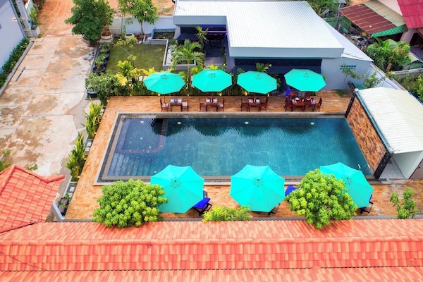 Una piscina al aire libre, sillones reclinables de piscina