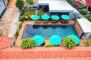 A rooftop swimming pool with multiple umbrellas and seating areas. - Tim & Sophy Angkor Inn (Siem Reap)