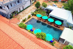 Enjoy a refreshing swim and unwind in the hotel's rooftop pool, surrounded by comfortable outdoor seating areas and lush greenery.