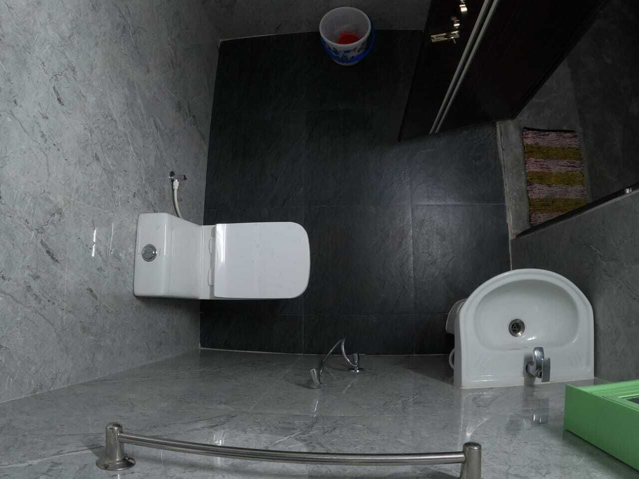 A bathroom with a toilet, a bidet, and a hand dryer.