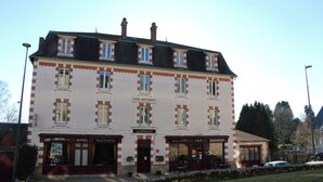 A multi-story building with a sign indicating it is a hotel and restaurant. - Hôtel Le Millésime (Meymac)
