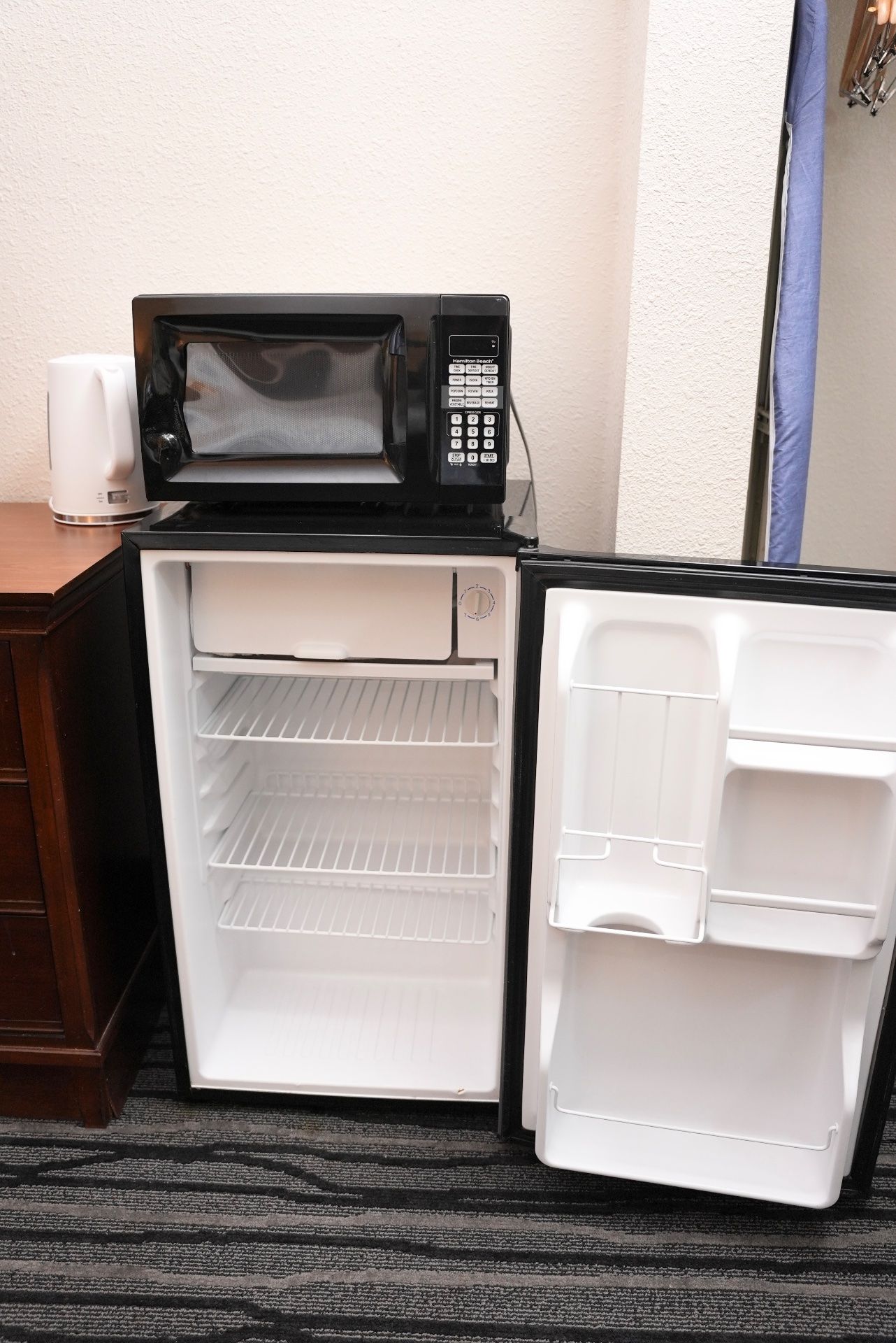 A compact kitchenette with a microwave, a small refrigerator, and a coffee maker.