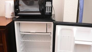 A compact kitchenette with a microwave, a small refrigerator, and a coffee maker.