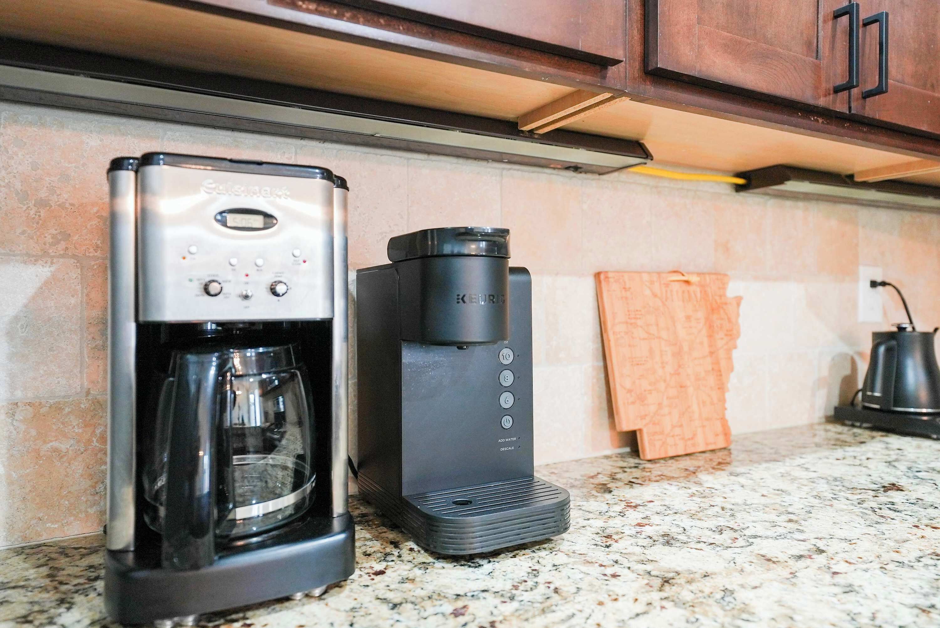 Una cafetera y un dispensador de cápsulas de café Keurig sobre una encimera de cocina.
