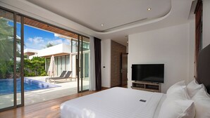 A modern hotel room with a large bed, a flat-screen TV, and a sliding glass door leading to a pool area.