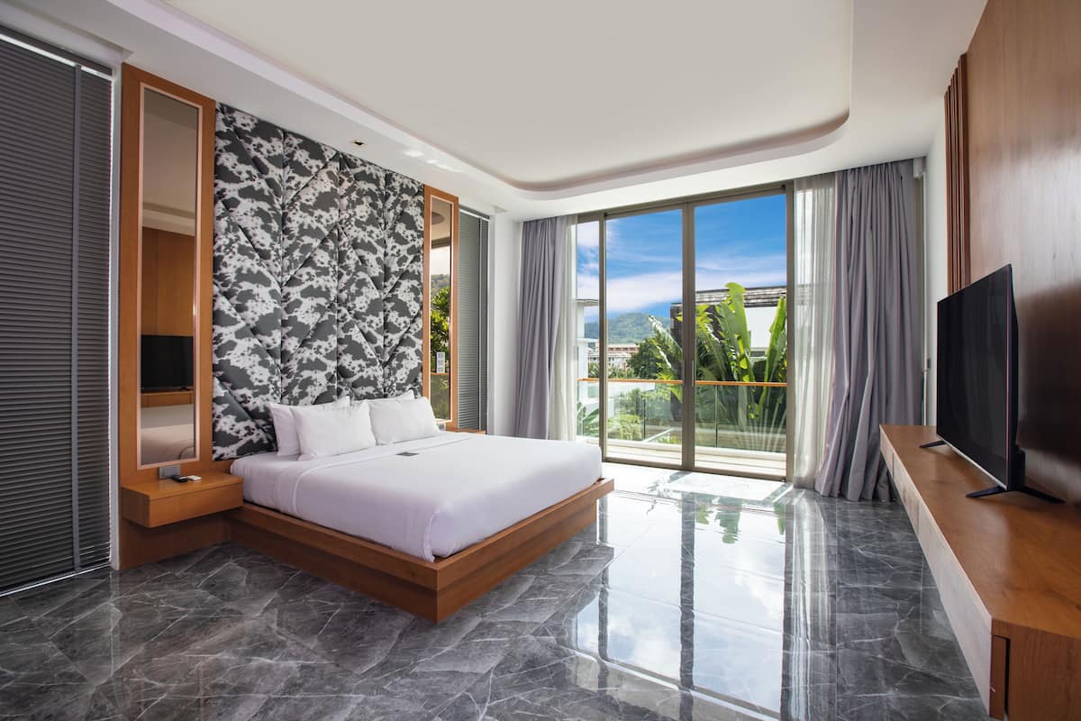 Quarto de hotel moderno com uma cama grande, uma TV e uma varanda com vista para a cidade.