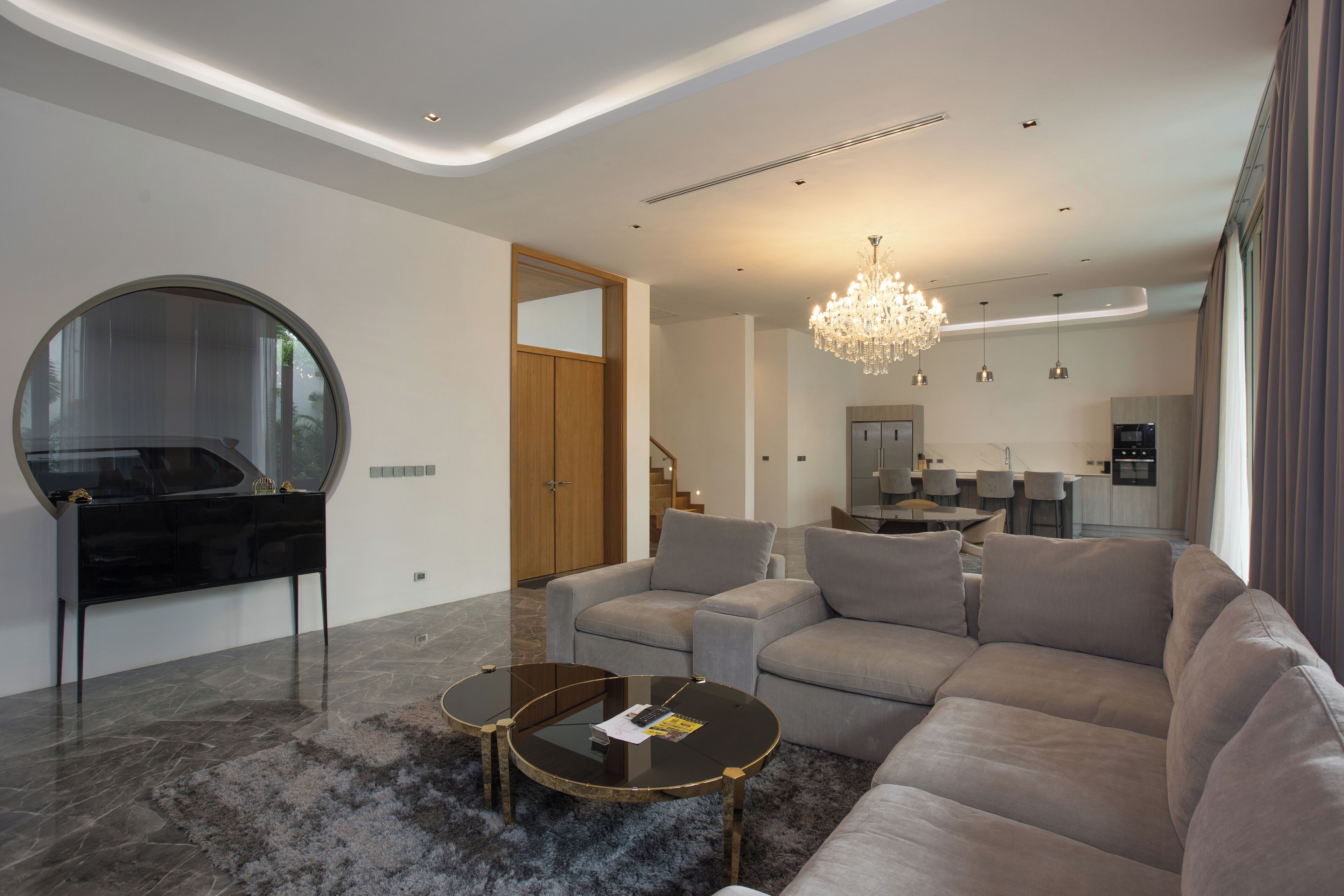 A modern living room with a sectional sofa, a glass coffee table, and a piano.