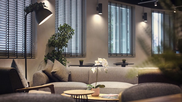 A modern living room with a sofa, a round table, and a potted plant. - Hmlet Kada at Maxwell (Singapore)