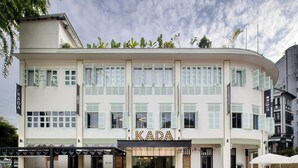 A building with a curved facade, multiple windows with shutters, and a sign reading "KADA". - Hmlet Kada at Maxwell (Singapore)