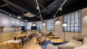 A modern living space with a dining area, sofas, and a kitchen. - Hmlet Kada at Maxwell (Singapore)