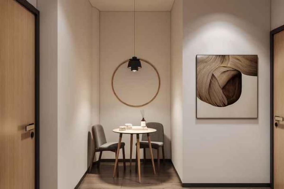 A hallway with a round table, chairs, a pendant light, and a framed abstract artwork on the wall.