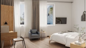 A modern bedroom with a wooden floor, a desk with a lamp, a grey armchair, a bedside table with a vase, and a bed with a white duvet. - Hmlet Kada at Maxwell (Singapore)