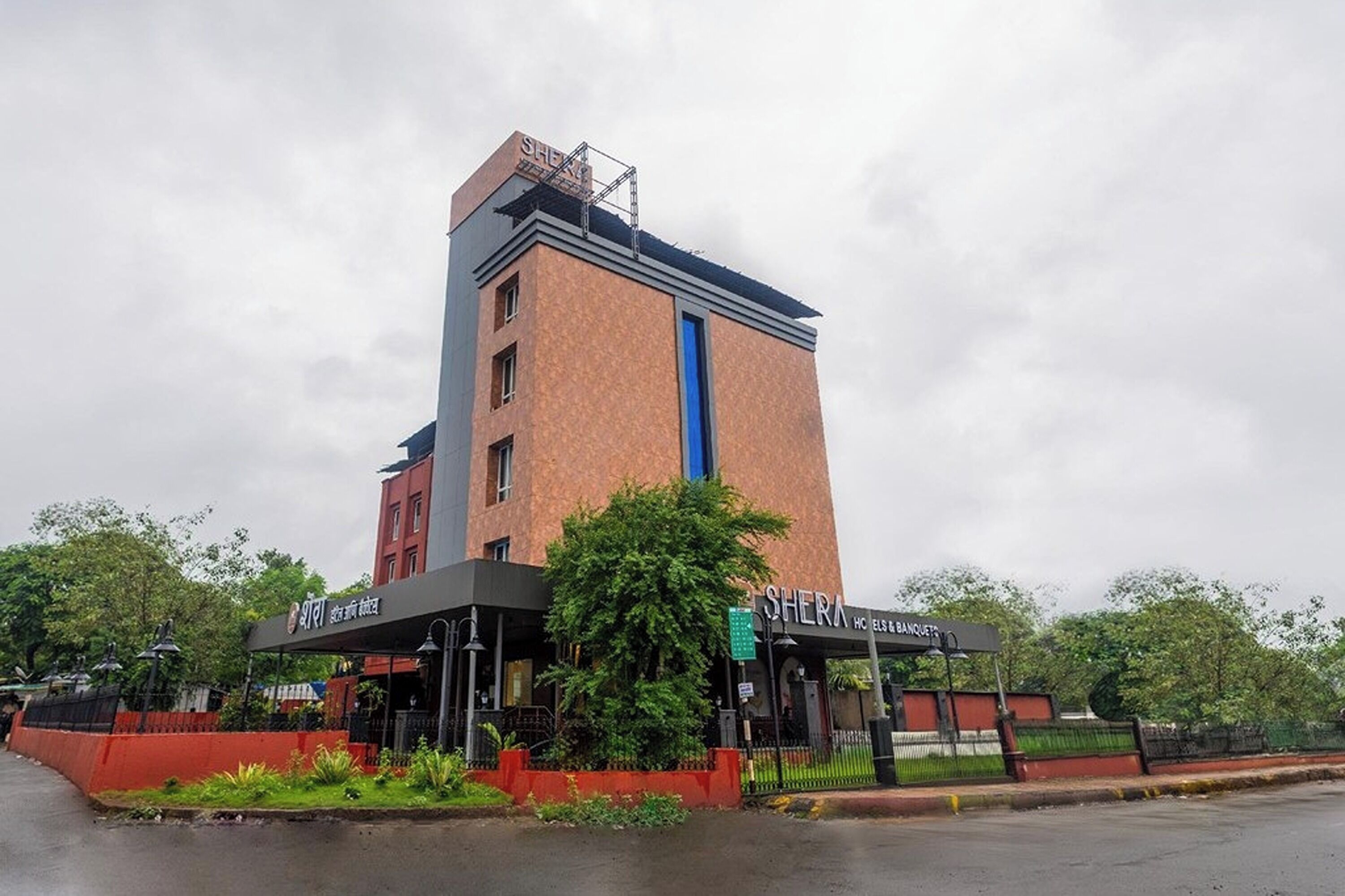 A hotel with a prominent tower, a covered entrance, and a sign for a restaurant.