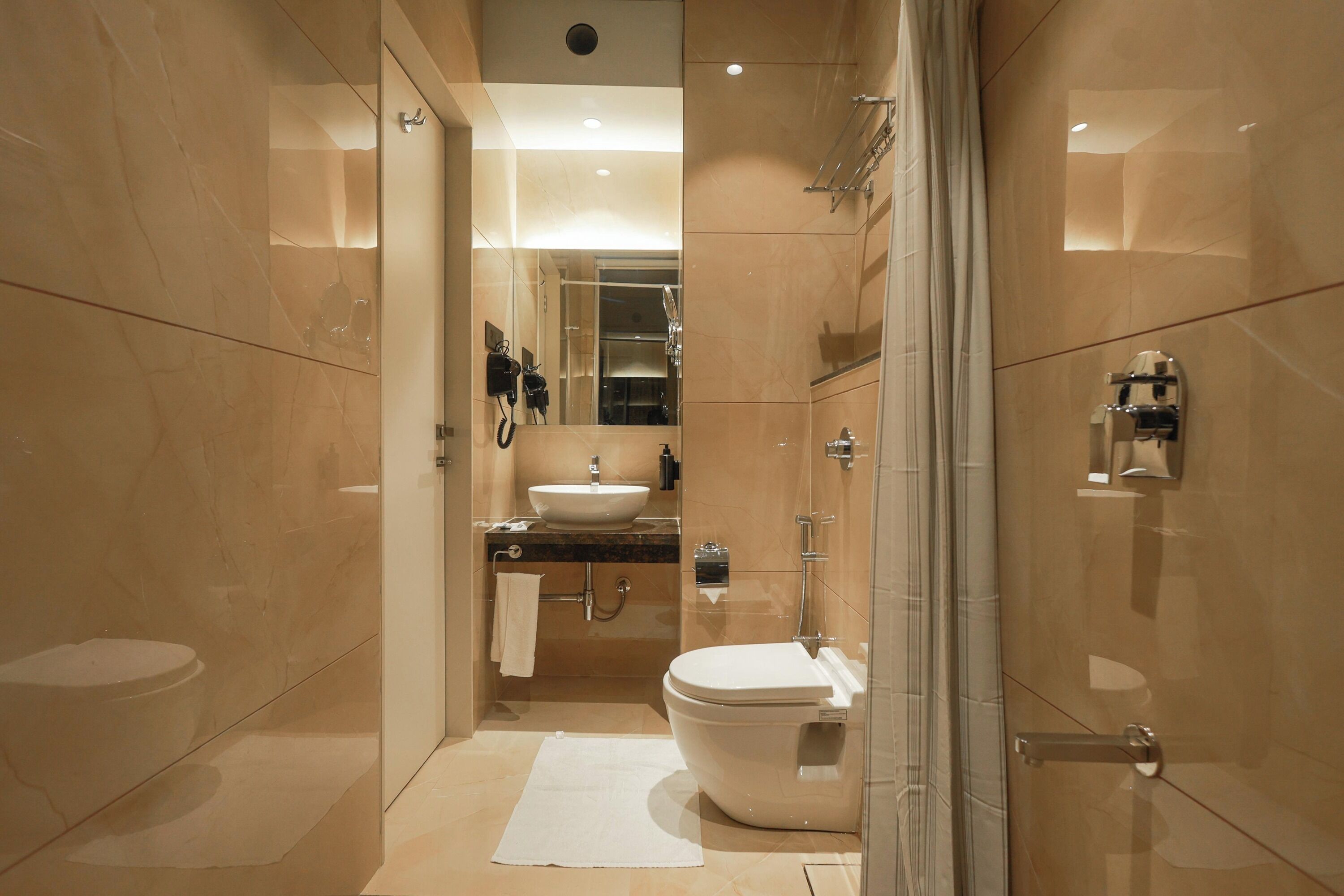 Une salle de bain moderne équipée de toilettes, d’un lavabo et d’une douche.