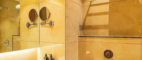 A modern bathroom with a large mirror, a sink, and a toilet.