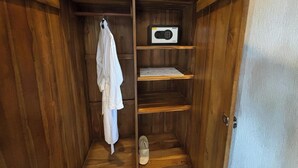 Un armario de madera con un perchero, una radio y estantes.