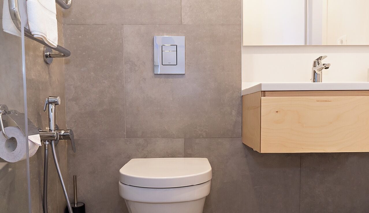 Une salle de bain moderne équipée de toilettes, d’une douche et d’un lavabo.