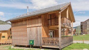 A wooden cabin with a balcony, a chimney, and a green mailbox. - Nice chalet with infrared sauna (Sankt Georgen am Kresichberg)