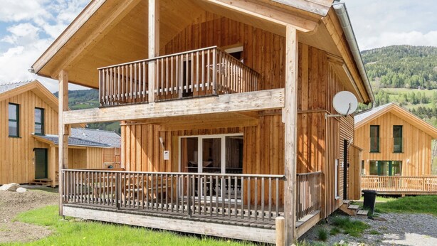 A wooden chalet with a balcony, a satellite dish, and a view of the surrounding landscape. - Nice chalet with infrared sauna (Sankt Georgen am Kresichberg)