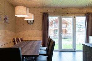 Enjoy meals in this cozy dining area with a large sliding door leading to a balcony offering a view of the surrounding landscape.
