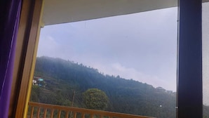 A balcony with a view of a hilly landscape.