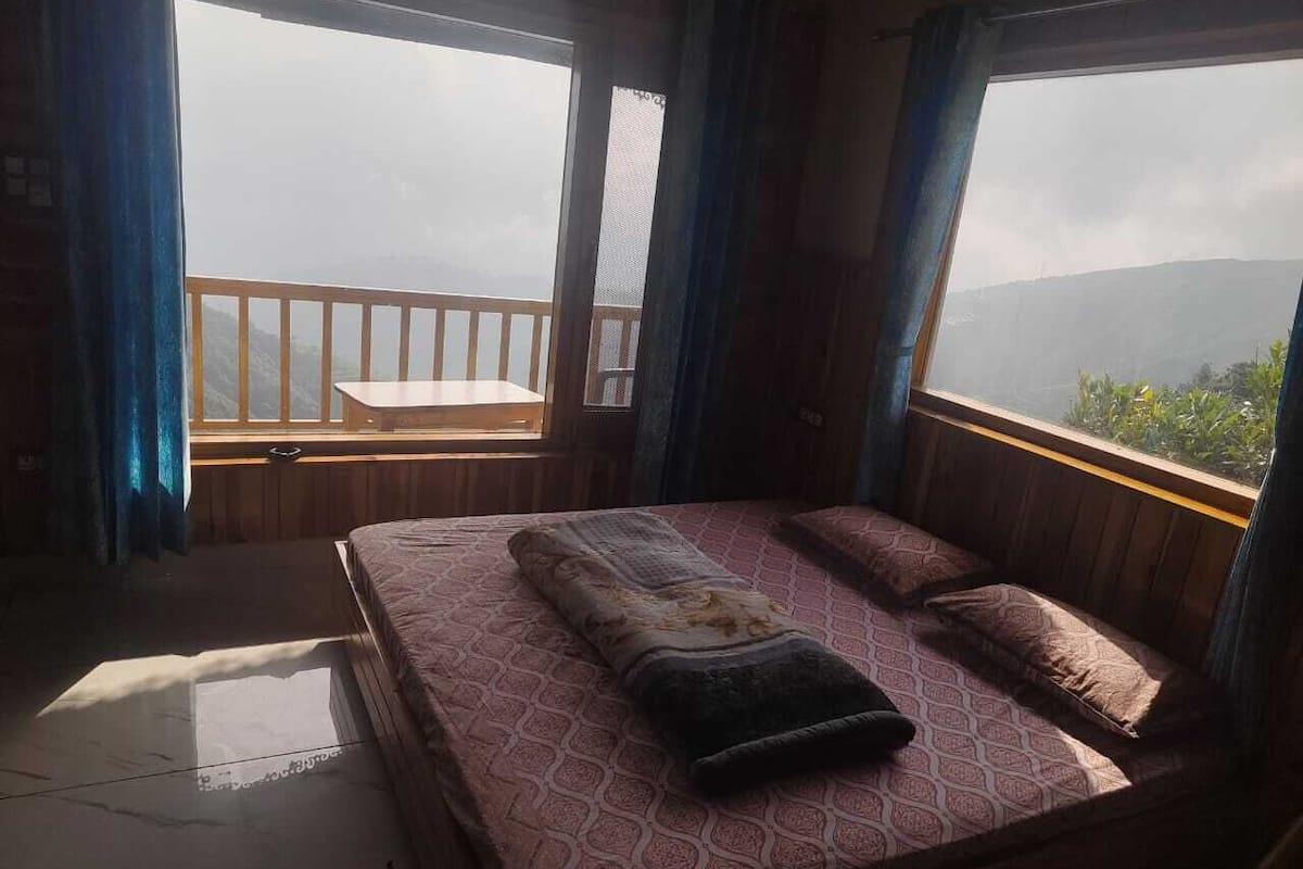 A bedroom with a bed, a window, and a balcony.