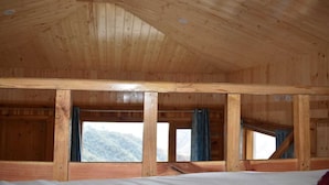 A wooden cabin with a high ceiling and large windows.