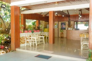 A spacious outdoor area with a seating arrangement and potted plants. - Casa Felicisima Inn (Puerto Princesa)