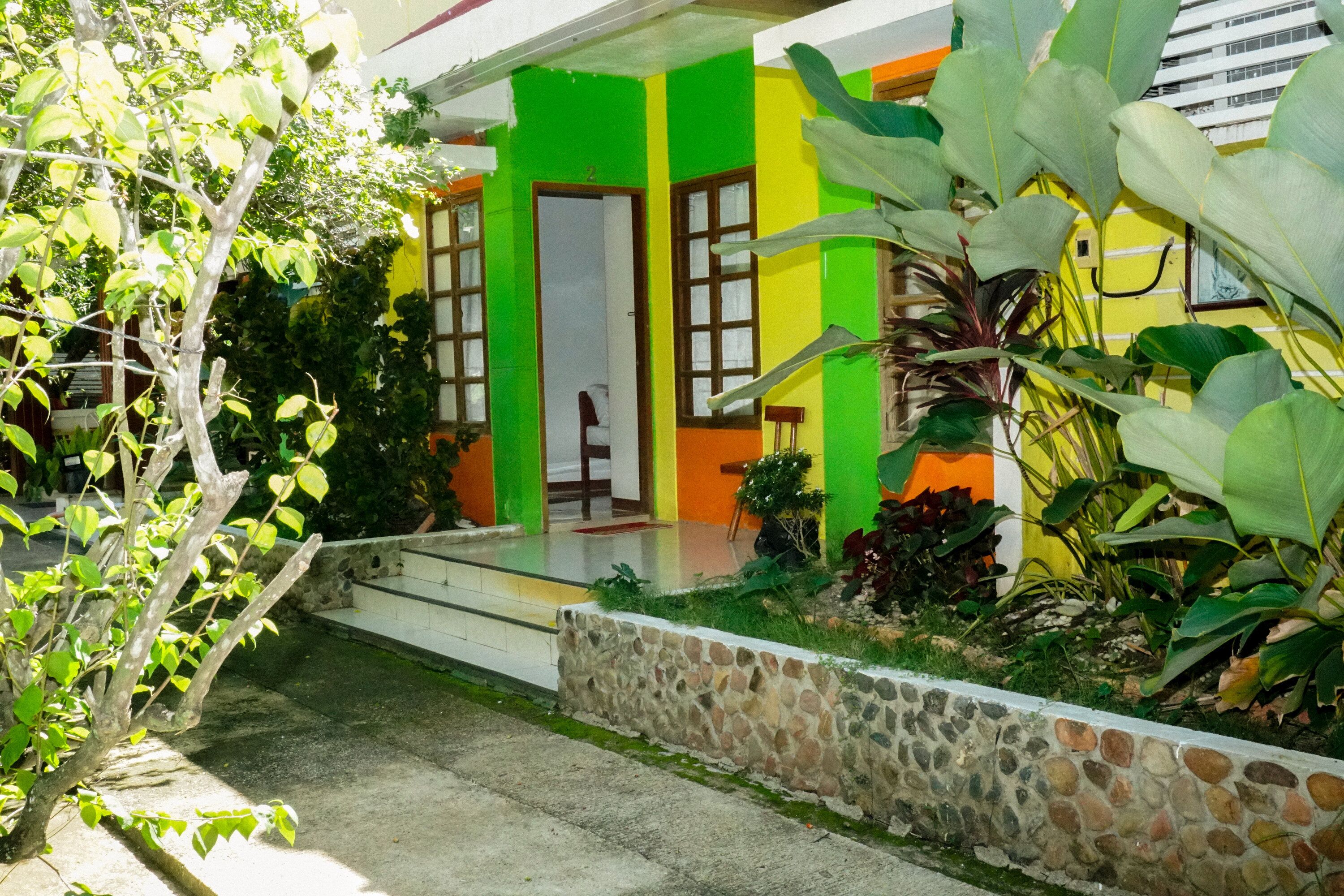 Una casa con pared de piedra, un porche y una puerta.