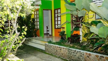 Una casa con pared de piedra, un porche y una puerta.