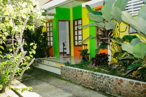 A house with a stone wall, a porch, and a door. - Casa Felicisima Inn (Puerto Princesa)