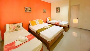 A hotel room with two beds, orange walls, and a door. - Casa Felicisima Inn (Puerto Princesa)