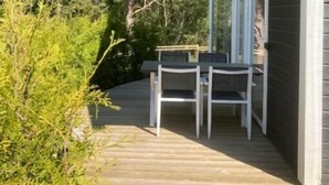 A house with a deck, surrounded by trees. - Brygghuset (Rockneby)