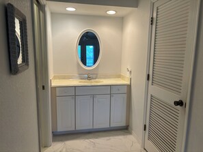 Une salle de bain avec un meuble-lavabo, un évier et un miroir.