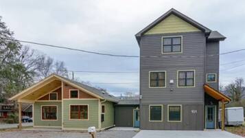 A two-story house with a garage, a covered porch, and a small attached shed.