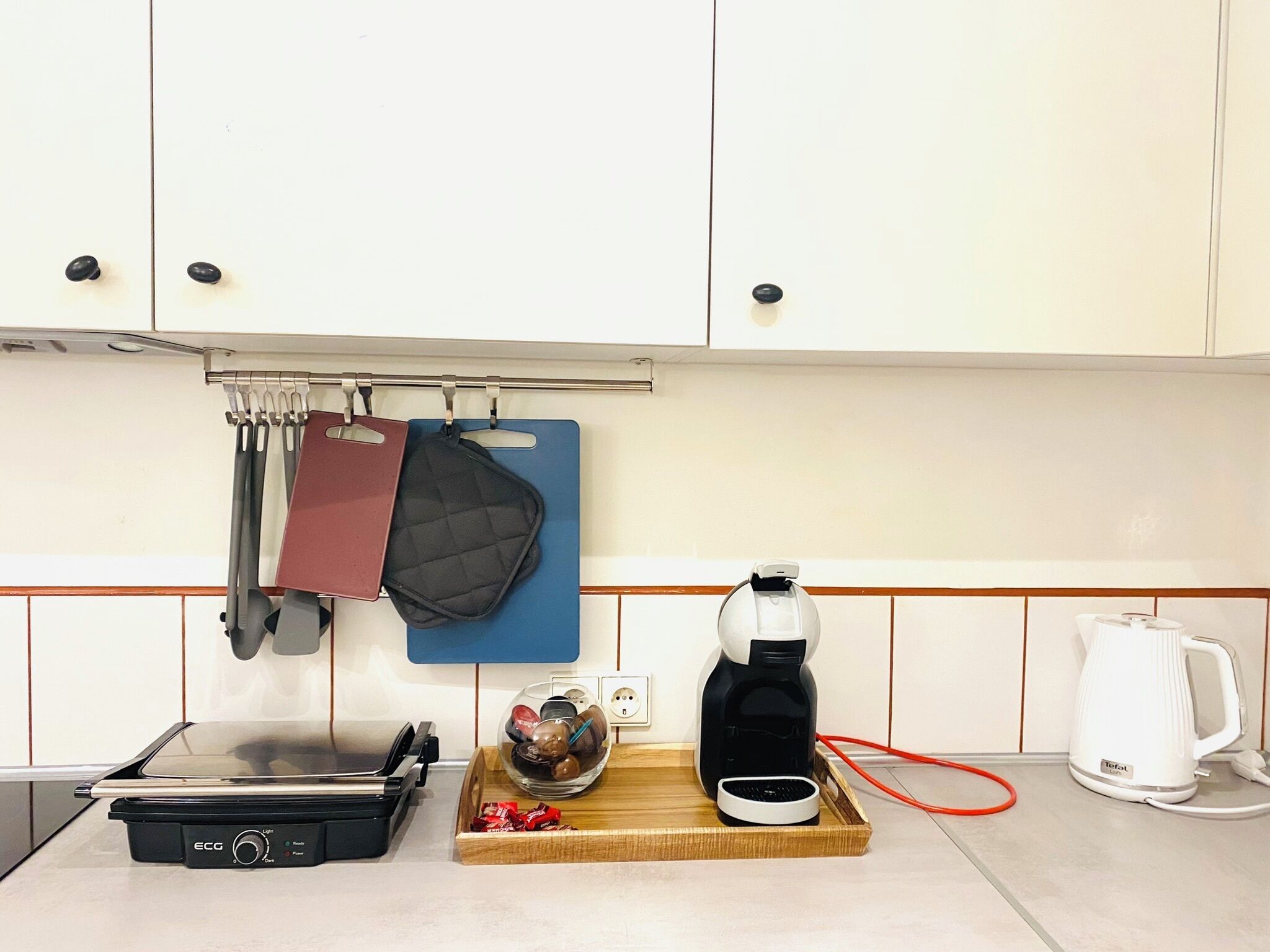 Eine Küche mit Herd, Kaffeemaschine und Wasserkocher.