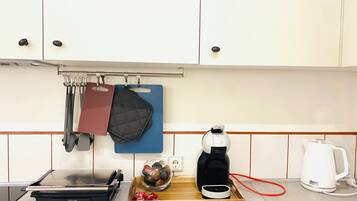 Eine Küche mit Herd, Kaffeemaschine und Wasserkocher.