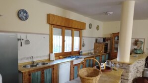 A kitchen with wooden cabinets, a sink, and a countertop. - Casa Rural Cortijo Paulenca  (Almería)