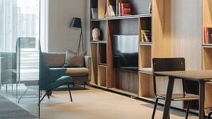 A modern living room with a sofa, a coffee table, and a bookshelf. - LURICH Residences (Tallinn)